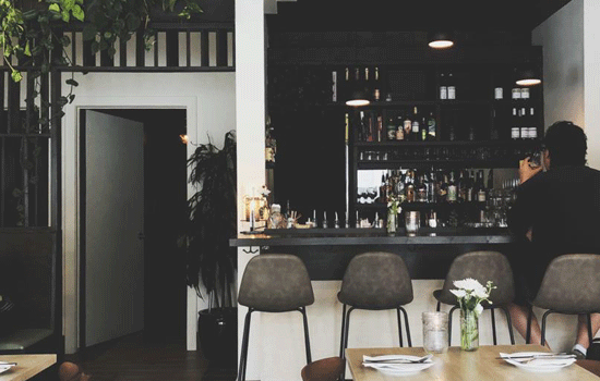 A person sits at a bar in a vegetarian restaurant. Courtesy of The Allium